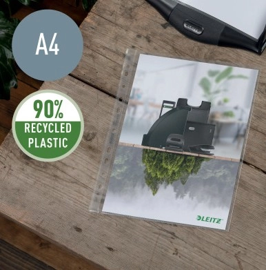 Das Bild zeigt eine Leitz Prospekthülle im Format A4, die auf einem Holztisch liegt und ein Deckblatt mit einem Bild von Leitz Büroprodukten enthält. Ein Symbol weist auf das verwendete Recyclingmaterial hin.