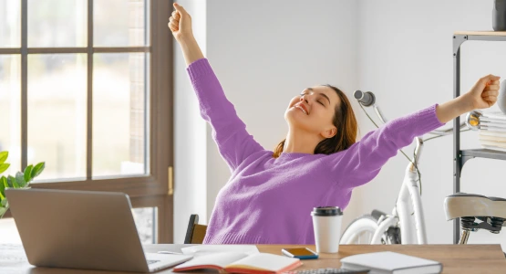 Eine Frau streckt sich an Ihrem Arbeitsplatz.