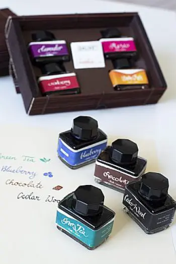 Mehrere Tintenfässer mit Dufttinten von Online stehen auf einem Tisch.