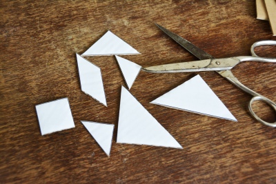 Zugeschnittene Tangram-Formen aus Pappe auf Holztisch