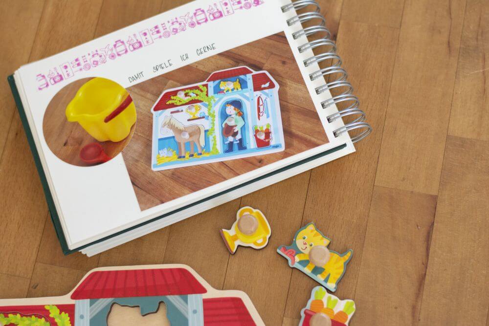 Ein Trostalbum für Kindergartenkinder: Eingeklebt sind zwei Fotos von Lieblingsspielsachen, davor liegt ein Kinderpuzzle.