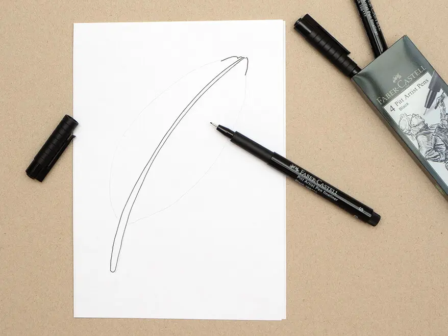 Auf ein Blatt wurde mit einem Pigmentliner von Faber-Castell der Kiel einer Vogelfeder gemalt. Ein Etui mit weiteren Finelinern liegt daneben. Foto: Johanna Rundel
