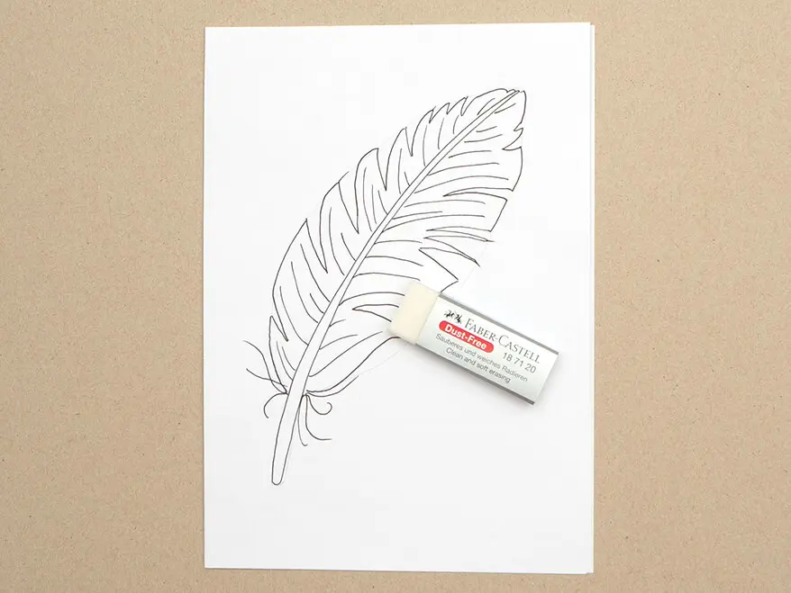 Auf ein Blatt wurde mit einem Pigmentliner eine Vogelfeder gemalt. Ein Radiergummi von Faber-Castell liegt darauf. Foto: Johanna Rundel