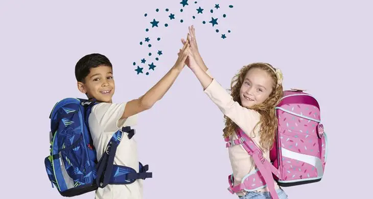 Zwei Kinder mit Schulranzen von DerDieDas geben sich ein High Five.