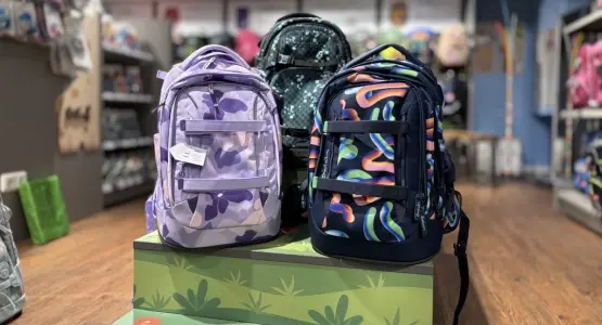 Auf einem Podest stehen drei Schulrucksäcke der Kollektion 2025 von satch und coocazoo