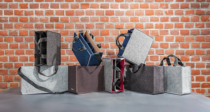 Desk Sharing Bags von SIGEL in verschiedenen Größen und Farben vor roter Ziegelwand.