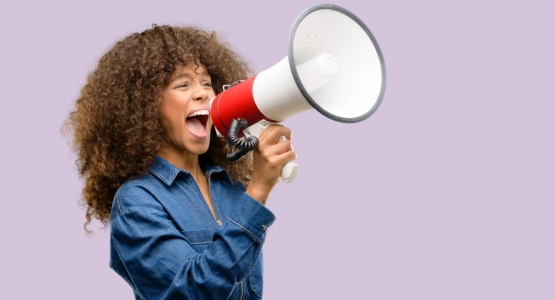 Eine Frau schreit in ein Megafon.