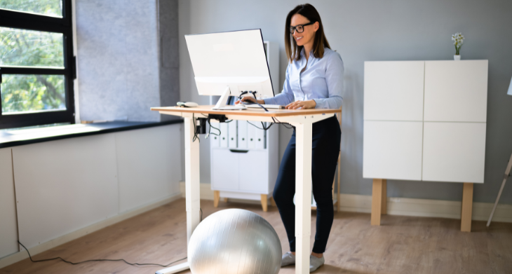 Eine Frau steht an Ihrem Schreibtisch.