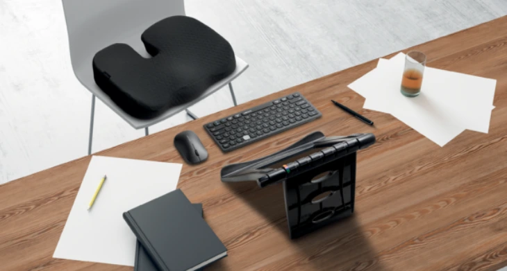 Ergonomisches Sitzkissen und Arbeitsplatz mit Dokumentenhalter und Tastatur.