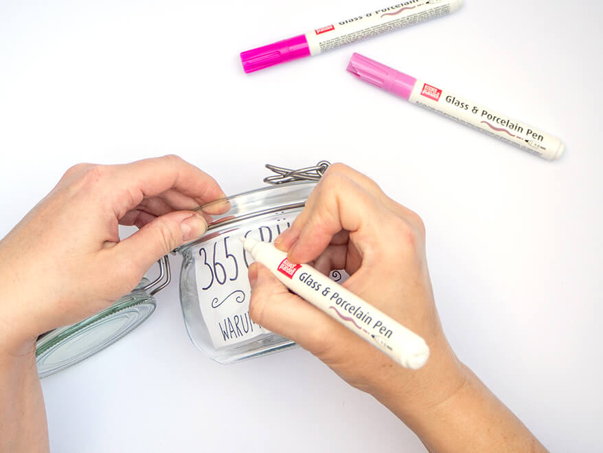 Mit einem schwarzen Glass & Porcelain Pen von Knorr Prandell wird "365 Gründe, warum ich dich liebe" auf ein Vorratsglas geschrieben. Foto: Johanna Rundel 