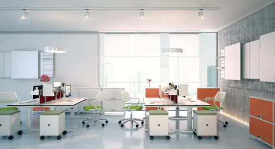 Mehrere Menschen sitzen in einem hell und freundlich eingerichtetem Büro an einem großen Tisch.