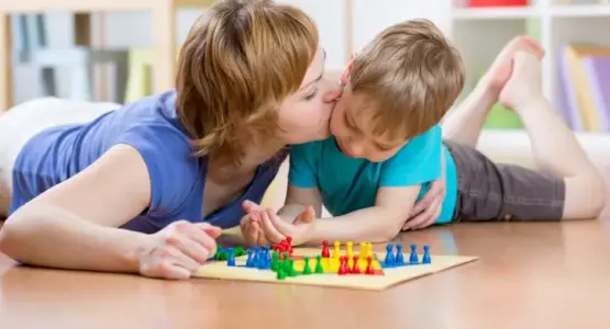 Eine Mutter spielt mit ihrem Kind Mensch ärgere dich nicht.  