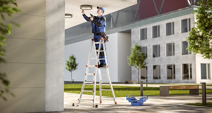 Handwerker arbeitet auf einer Hailo Teleskopleiter im Außenbereich