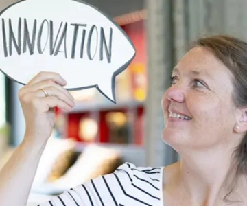 Eine Frau hält ein Schild hoch.