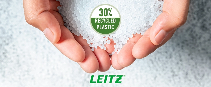 Das Bild zeigt zwei Hände, die kleine weiße Kunststoffpellets halten. Ein Symbol mit der Aufschrift '30% Recycled Plastic' weist darauf hin, dass das Material zu 30 % aus recyceltem Kunststoff besteht. Im unteren Bereich des Bildes ist das Leitz-Logo zu sehen.