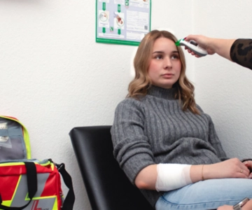 Die Temperatur einer Frau wird gemessen.