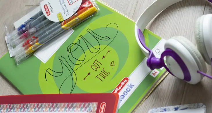 Auf einem Schulheft steht der Spruch „You got this.“ Drumherum liegen ein Kopfhörer und Fineliner.