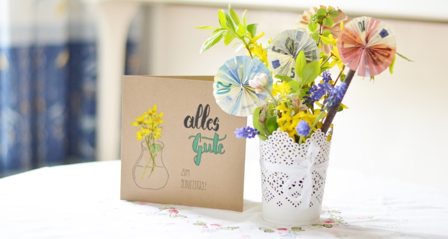 Selbst gestaltete Geburtstagskarte und Blumenstrauß mit Blüten aus gefalteten Geldscheinen.