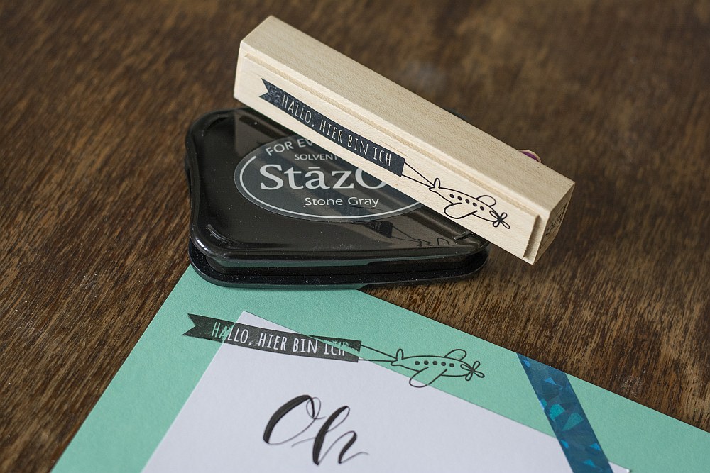 Holzstempel mit Flugzeugmotiv und Stempelkissen auf einem Tisch