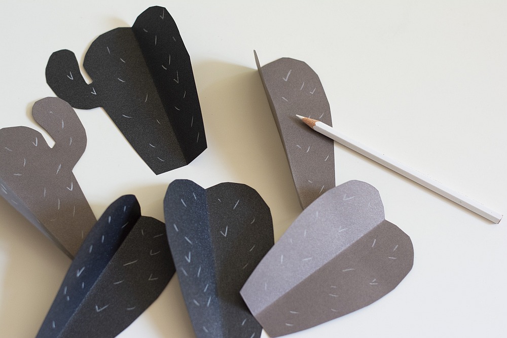 Kaktusteile aus schwarzem Bastelpapier mit weißen Strichen als Stacheln bemalt