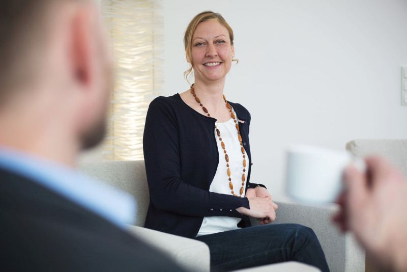 Frau sitzt im Gespräch einem Mann gegenüber