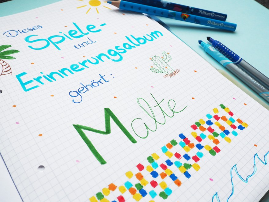 Handgeschriebenes Spiele- und Erinnerungsalbum mit bunten Verzierungen und Namen.