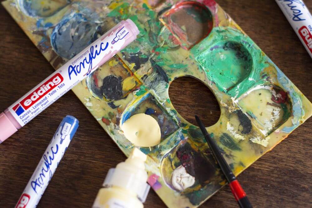 Nahaufnahme einer Künstlerpalette mit Acrylfarben und Acrylmarkern von Edding.