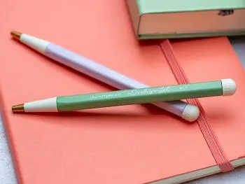 Auf einem roten Notizbuch liegen zwei Drehgriffel von LEUCHTTURM1917. Foto: Johanna Rundel