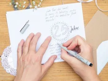 Jemand schreibt mit einem extrafeinen Pigmentmarker von Faber-Castell einen Text in eine Glückwunschkarte zur Silberhochzeit. Foto: Johanna Rundel