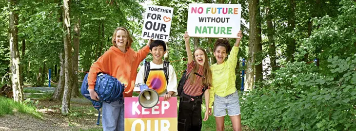 Vier Kinder mit Schulrucksäcken von coocazoo halten Schulder für mehr Klimaschutz in die Luft.