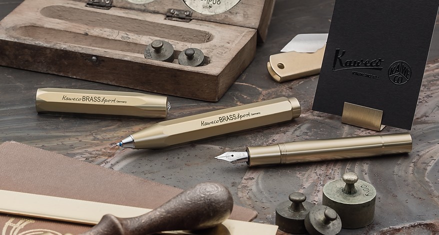 Kaweco BRASS Sport Schreibgeräte neben Vintage-Waagen und Schreibutensilien.