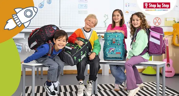 Vier Kinder sitzen auf einer Banke, neben ihnen stehen Schulranzen von Step by Step.