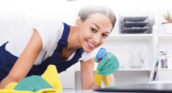 Zwei Hände ziehen ein Papierhandtuch aus einem Handtuchspender.