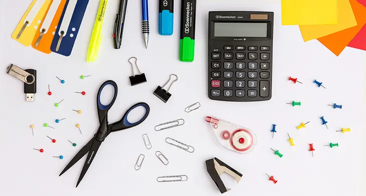 Auf einem weißen Tisch liegen verschiedene Büroartikel von Soennecken. Rechts oben ist das Logo der Marke abgebildet.