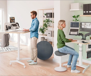 Zwei Personen arbeiten an ergonomischen Arbeitsplätzen.