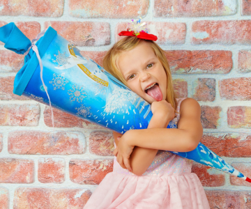 Mädchen mit Schultüte streckt die Zunge raus