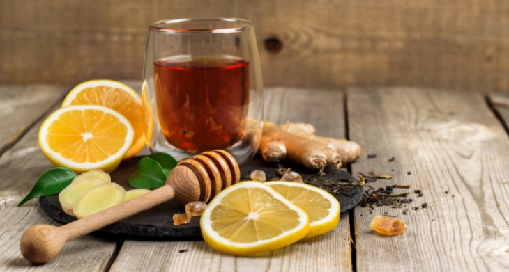 Tee mit frischer Zitrone, Ingwer und Honig auf rustikalem Holztisch