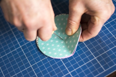 Loch wird mit Nadel in gefalteten Papierkreis gestochen