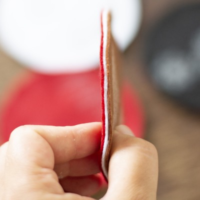 Drei zusammengeklebte Filzstücke in Rot, Weiß und Braun