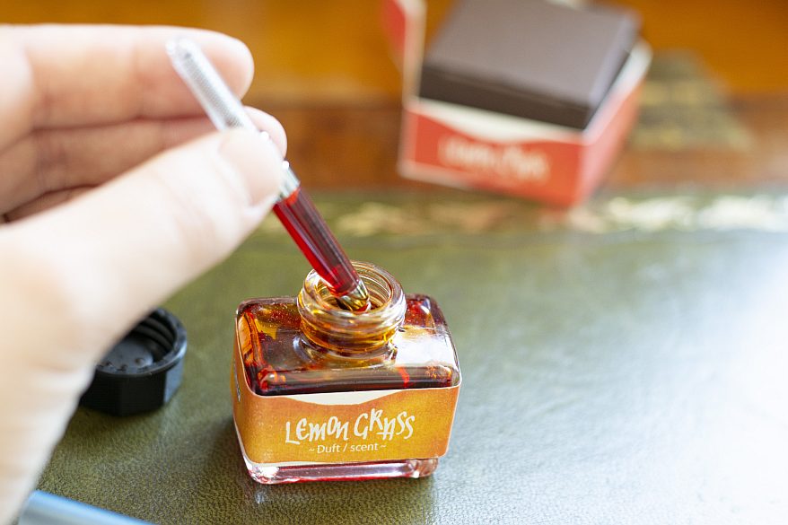 Tintenkonverter wird in geöffnete „Lemongrass“-Dufttinte eingetaucht.