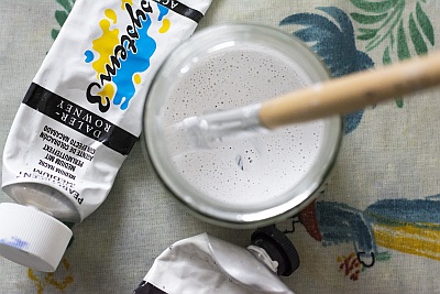 Acrylfarbe und Pinsel in einem Glas zum Anrühren