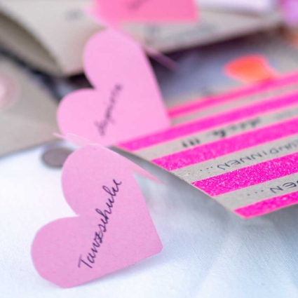 Eine Kette aus Papierherzen, die mit verschiedenen Begriffen beschriftet wurde.