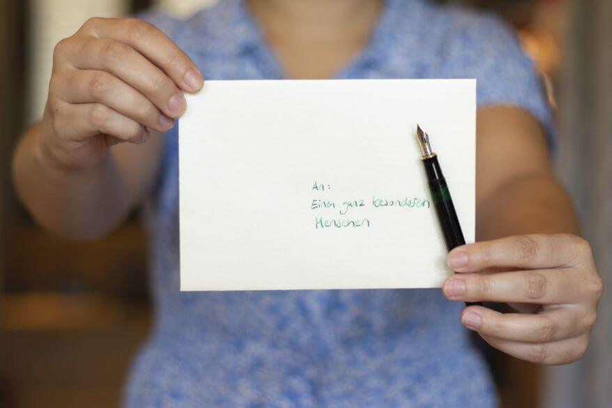 Zwie Hände halten einen Briefumschlag, auf dem "an einen ganz besonderen Menschen" geschrieben steht, in die Kamera. Eine Hand hält dazu einen Füller "Souverän" von Pelikan.