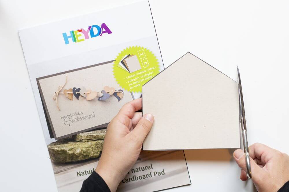 Wichteltür zu Weihnachten basteln, Bastelanleitung Schritt 1: Das Umriss des Wichtelhauses auf einem grauen Karton von Heyda ausschneiden.