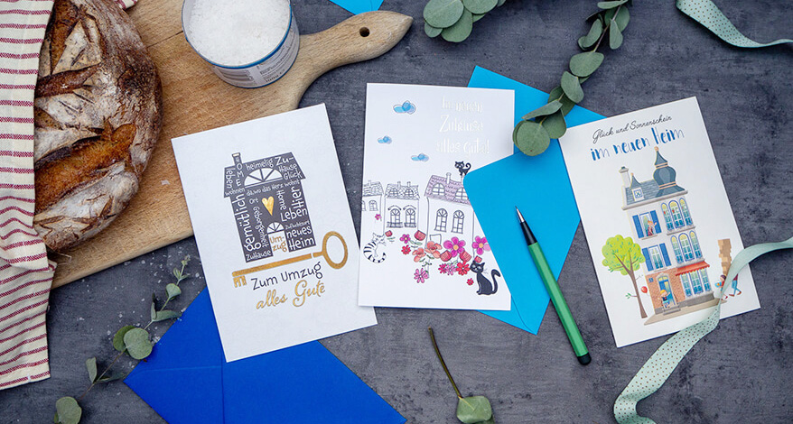 Auf einem Tisch liegen selbstgestaltete Karten mit Glückwünschen zum Einzug.