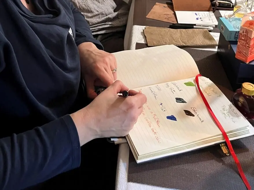 Jemand testet verschiedene Füllfederhalter in einem Notizbuch.