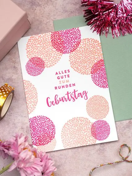 Eine Letterpress-Glückwunschkarte zum runden Geburtstag in Rosatönen von Rössler liegt auf einem rosa Untergrund. Foto: Johanna Rundel 