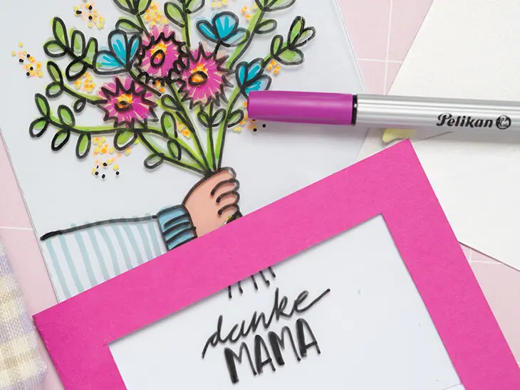 Eine mit Materialien von Pelikan und Herlitz selbstgebastelte Schiebekarte zum Muttertag liegt auf einem rosa Untergrund. Das Motiv ist ein Arm der einen Blumenstrauß hält. Foto: Johanna Rundel