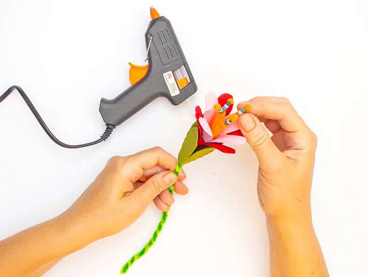 Jemand klebt orangefarbenen Pfeifenputzer von KNORR prandell in eine Blüte aus einem Eierkarton. Foto: Johanna Rundel