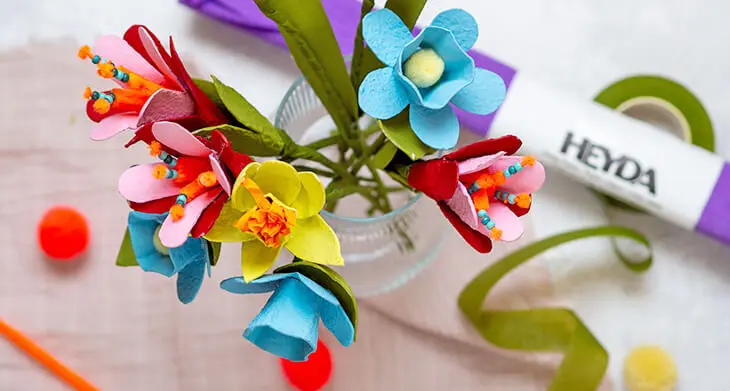 Ein bunter Blumenstrauß aus Papierblumen die aus Eierkartons gebastelt wurden. Daneben Bastelmaterialien von HEYDA und KNORR prandell. Foto: Johanna Rundel